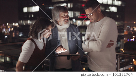 Business team, tablet and night on city building rooftop talking global networking, digital marketing and social media. Man and woman with 5g network on mobile stock market app for innovation idea 101351704