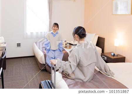 入住後坐在房間床上的年輕女子 101351867