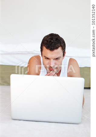 Its never too early to start blogging. A handsome man lying on his bed working on his laptop. Its never too early to start blogging. A handsome man lying on his bed working on his laptop. 101352140