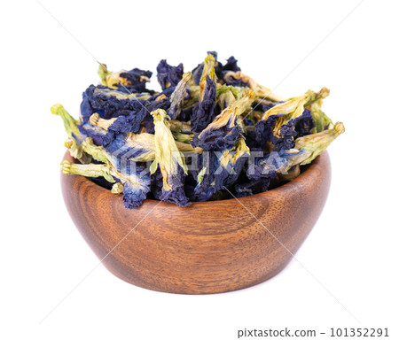 Butterfly pea flowers in wooden bowl, isolated on white background. Blue herbal tea. Clitoria Ternatea. Butterfly pea flowers in wooden bowl, isolated on white background. Blue herbal tea. Clitoria Ternatea. 101352291