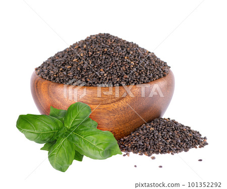 Basil seeds in wooden bowl, with green basil leaves, isolated on white background. Ocimum basilicum. Basil seeds in wooden bowl, with green basil leaves, isolated on white background. Ocimum basilicum. 101352292