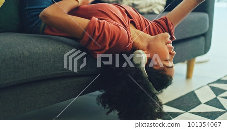 Headphones, listening and dance of black woman on a sofa excited for subscription service, technology and home connection. Happy, relax and girl portrait dancing on couch while listening to music app 101354067
