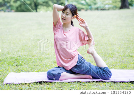 一個女人在新鮮的綠色做瑜伽 101354180