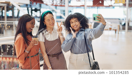 Selfie, friends and social media with woman together posing for a photograph in a mall or shopping center. Phone, social media and smile with a happy female friend group taking a picture for fun Selfie, friends and social media with woman together posing for a photograph in a mall or shopping center. Phone, social media and smile with a happy female friend group taking a picture for fun 101354285