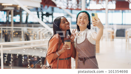Phone selfie, women and friends with peace sign at mall taking pictures for social media. Bokeh, hand gesture and girls taking photo on mobile smartphone for profile picture or happy memory together. 101354698