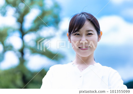 一個微笑的女人享受著新鮮的綠色 101355099