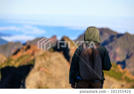 Traveling woman standing on the top of the mountain and watching beautiful view of majestic mountains Traveling woman standing on the top of the mountain and watching beautiful view of majestic mountains 101355428