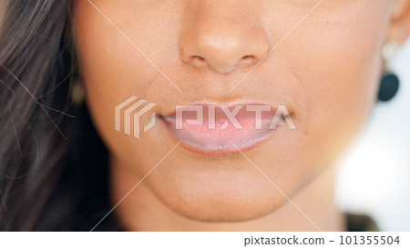 Smiling, beautiful and fresh female face winking feeling fun, silly and playful. Portrait of a happy woman head with perfect skin and healthy teeth. Closeup of a carefree natural beauty with a smile 101355504