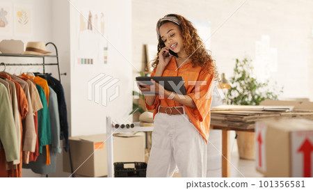 Logistics, fashion and business owner on a phone call for a delivery of clothes in a clothing boutique retail store. Supply chain, woman and entrepreneur ordering inventory, cargo and boxes of stock Logistics, fashion and business owner on a phone call for a delivery of clothes in a clothing boutique retail store. Supply chain, woman and entrepreneur ordering inventory, cargo and boxes of stock 101356581
