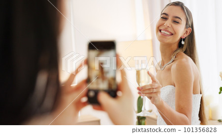 Smartphone photography of bride with champagne glass for wedding celebration to post on social media app. Smile portrait photos or picture taken of woman on digital cellphone and celebrate with wine 101356828