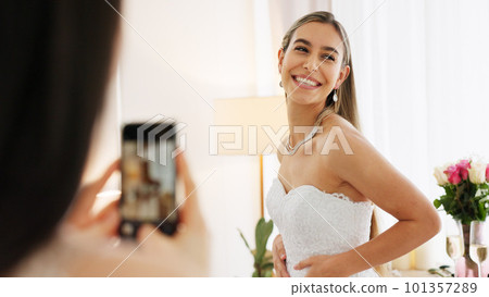 Smartphone photography of woman with wedding jewelry for luxury, fashion and wealth with smile portrait in a boutique or hotel. Bride in white dress with diamond or silver necklace for social media 101357289