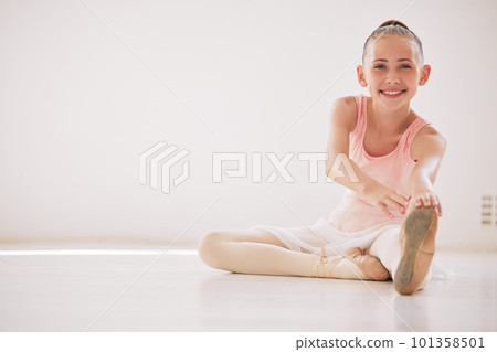 Happy ballet dancer girl stretching on the floor in a dance studio with mockup white background. Portrait ballerina kid smile while learning or training with legs in class for a performance mock up Happy ballet dancer girl stretching on the floor in a dance studio with mockup white background. Portrait ballerina kid smile while learning or training with legs in class for a performance mock up 101358501