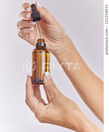 Skincare serum, essential oil and cosmetic product in woman hand for perfect, smooth skin or reduce wrinkles isolated on studio background. Closeup hands using body care or anti aging liquid drop 101359031