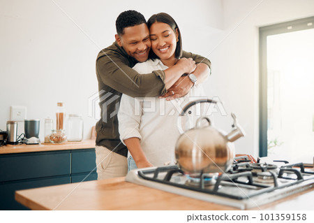 Romantic, love and bonding couple hugging while enjoying quality time together at home. Loving husband showing affection, care and embrace to his relaxing wife while making tea in the kitchen Romantic, love and bonding couple hugging while enjoying quality time together at home. Loving husband showing affection, care and embrace to his relaxing wife while making tea in the kitchen 101359158
