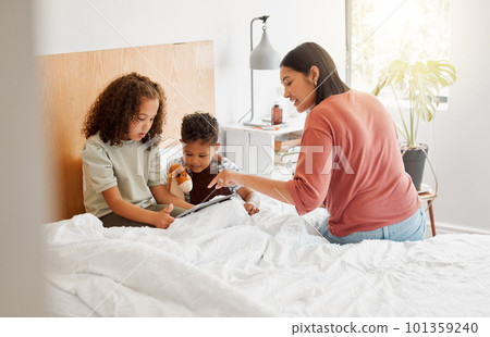 Mother and children learning on digital tablet online, family bonding with internet in bedroom and watching movies in bed at home. Boy and girl streaming videos, parent showing and teaching with tech 101359240