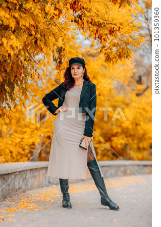 A woman walks outdoors in autumn, enjoys the autumn weather. 101359360