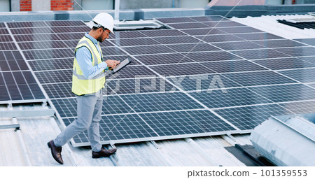 Electrician checking solar panels technology on the roof of the building his working on. Professional engineer technician wearing a safety helmet looks closely at his modern renewable energy design Electrician checking solar panels technology on the roof of the building his working on. Professional engineer technician wearing a safety helmet looks closely at his modern renewable energy design 101359553