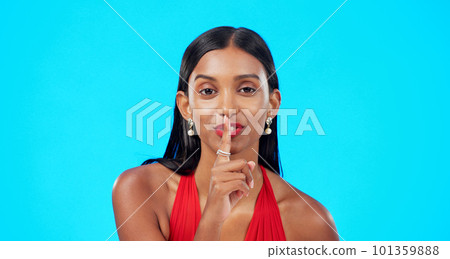 Secret, face and woman with finger on lips in studio, blue background and privacy sign. Portrait of indian model, silence and shush for quiet, gossip and whisper of confidential mystery, emoji or Secret, face and woman with finger on lips in studio, blue background and privacy sign. Portrait of indian model, silence and shush for quiet, gossip and whisper of confidential mystery, emoji or 101359888