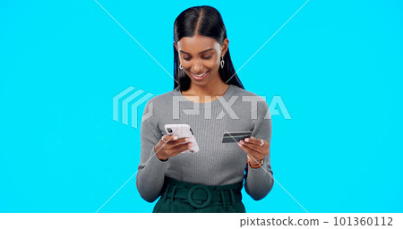 Online shopping, phone or girl with credit card in studio for payment via internet website or fintech. Happy smile, blue background or Indian woman typing money transfer via digital mobile banking Online shopping, phone or girl with credit card in studio for payment via internet website or fintech. Happy smile, blue background or Indian woman typing money transfer via digital mobile banking 101360112
