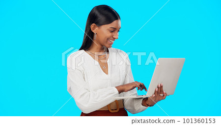 Business woman, laughing and laptop in a studio reading a funny email on computer. Isolated, blue background and young Indian female with happiness writing on a website with a smile feeling happy Business woman, laughing and laptop in a studio reading a funny email on computer. Isolated, blue background and young Indian female with happiness writing on a website with a smile feeling happy 101360153