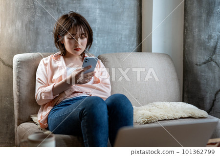 Young woman using a smartphone on the sofa Young woman using a smartphone on the sofa 101362799