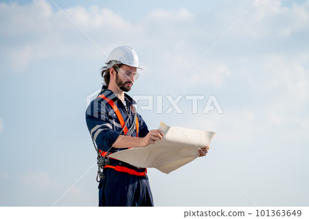 Smart engineer or technician man stand with holding drawiing paper and look to paper Smart engineer or technician man stand with holding drawiing paper and look to paper 101363649