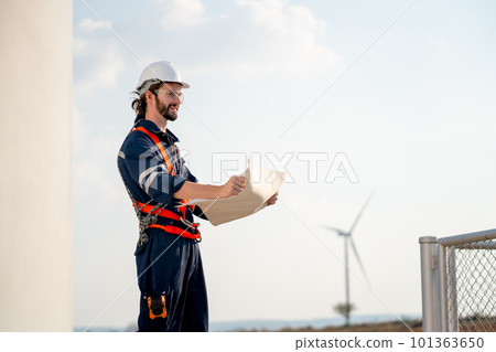 Engineer or technician man stand with holding drawiing paper and look forward also stand windmill Engineer or technician man stand with holding drawiing paper and look forward also stand windmill 101363650