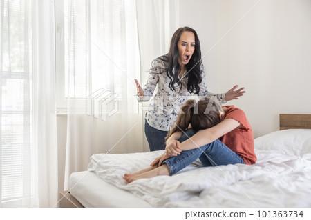 Abusive mother shouts at her daughter at home while the girl tries to hide her head between her legs Abusive mother shouts at her daughter at home while the girl tries to hide her head between her legs 101363734