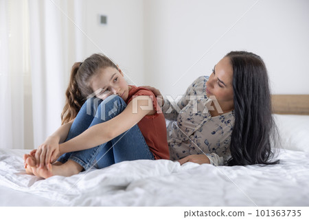 Adult woman tries to communicate with  a depressed and sad young girl at home 101363735