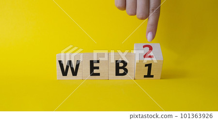 WEB 2 or 1 symbol. Businessman hand points at turned wooden cubes with words WEB 1 and WEB 2. Beautiful yellow background. Business and WEB concept. Copy space WEB 2 or 1 symbol. Businessman hand points at turned wooden cubes with words WEB 1 and WEB 2. Beautiful yellow background. Business and WEB concept. Copy space 101363926