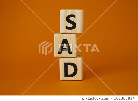Sad symbol. Wooden cubes with words Sad. Beautiful orange background. Business and Sad concept. Copy space. 101363934