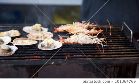 grilled scallops and sea shrimps with hot smoke on stove pan 101364769