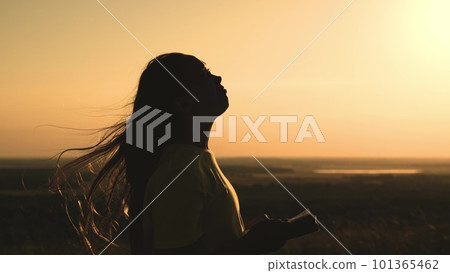 girl prays with bible her hands sunset. young girl asks for help. read prayer dawn. human faith dream. ask sky. relaxation concept. happy person lives faith. good book helps find way. pray park sun 101365462