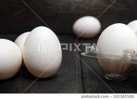 The white eggs are stacked in tray and on black vintage boards. Egg sorting in chicken farm 101365588