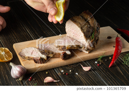 Chef squeezes fresh lemon juice onto the grilled sliced beef. Place for advertisement or prescription on dark background Chef squeezes fresh lemon juice onto the grilled sliced beef. Place for advertisement or prescription on dark background 101365709