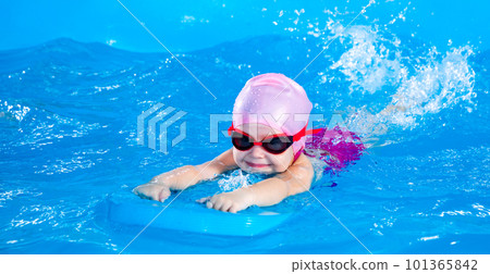 Little girl learning to swim in indoor pool with flutterboard Little girl learning to swim in indoor pool with flutterboard 101365842