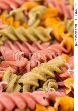 Rice vegetable pasta in the form of spirals, top view. Healthy rice pasta with tomatoes, celery, carrots and beets 101366184