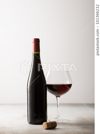 Bottle and glass of red wine with cork on light background. 101366232