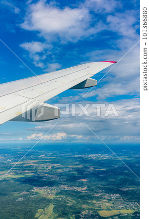 View of airplane wing, blue skies and green land during landing. Airplane window view. View of airplane wing, blue skies and green land during landing. Airplane window view. 101366880