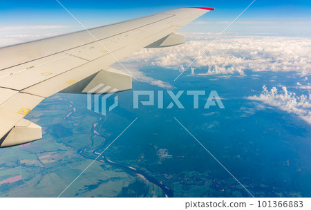 View from the airplane window at a beautiful cloudy sky and the airplane wing 101366883