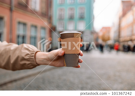 Beautiful and young girl in a coat drinking coffee on central square in Gdansk old town. Traveling Europe in autumn. High quality photo Beautiful and young girl in a coat drinking coffee on central square in Gdansk old town. Traveling Europe in autumn. High quality photo 101367242
