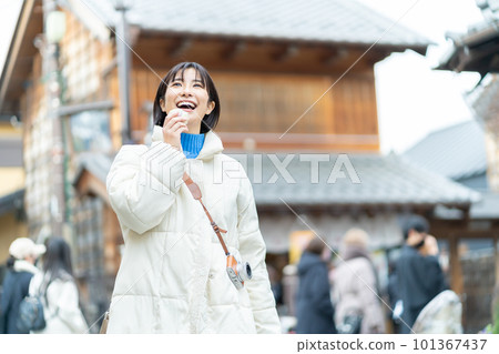 A woman eating while walking, a woman sightseeing, a woman, a trip, a smile, a trip alone, a commemorative photo 101367437