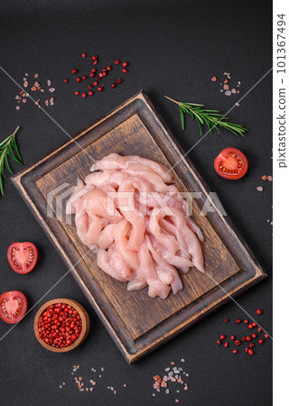 Raw chicken fillet cut into strips with spices and herbs 101367494