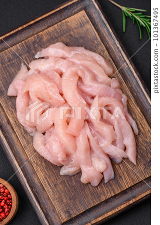 Raw chicken fillet cut into strips with spices and herbs Raw chicken fillet cut into strips with spices and herbs 101367495