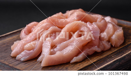 Raw chicken fillet cut into strips with spices and herbs 101367498