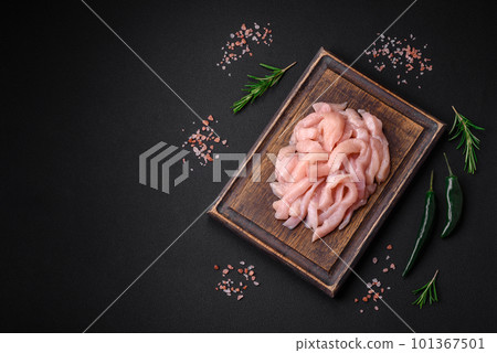 Raw chicken fillet cut into strips with spices and herbs 101367501