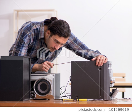 Young engineer repairing musical hi-fi system Young engineer repairing musical hi-fi system 101369619