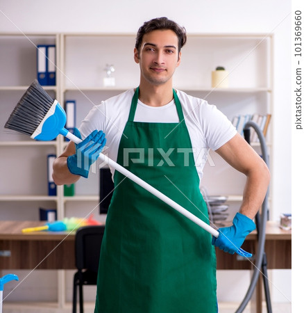 Young handsome contractor cleaning the office Young handsome contractor cleaning the office 101369660