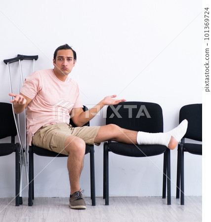 Young injured man waiting for his turn in hospital hall Young injured man waiting for his turn in hospital hall 101369724