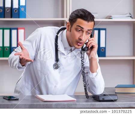 Young male doctor at the reception in the hospital Young male doctor at the reception in the hospital 101370225